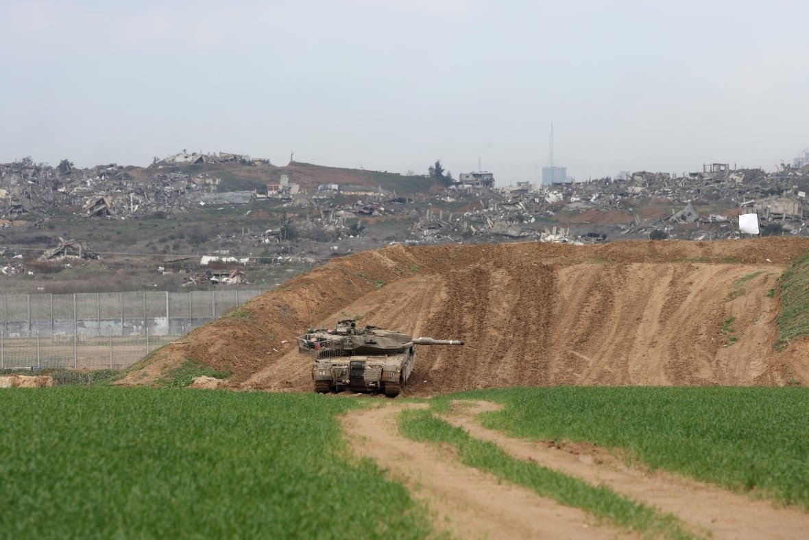 2198451529 An army tank stationed on a hill.