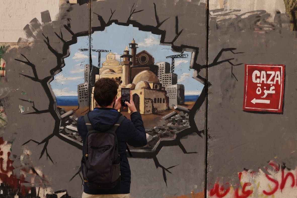2198456240 A man takes a picture of graffiti painting.