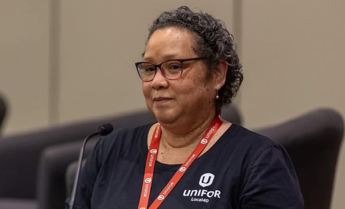 Hazel Harris and a meeting, wearing a Unifor shirt.