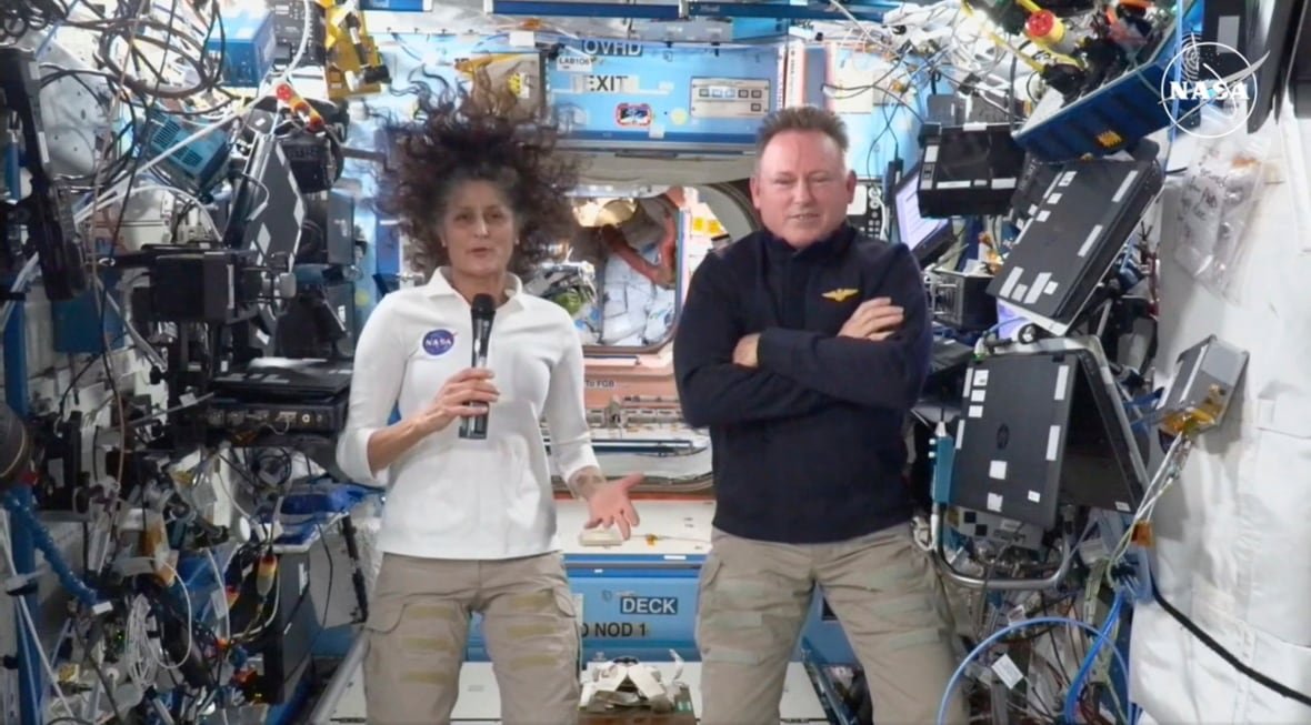 nasa-astronauts Two astronauts float in zero gravity inside a space station.