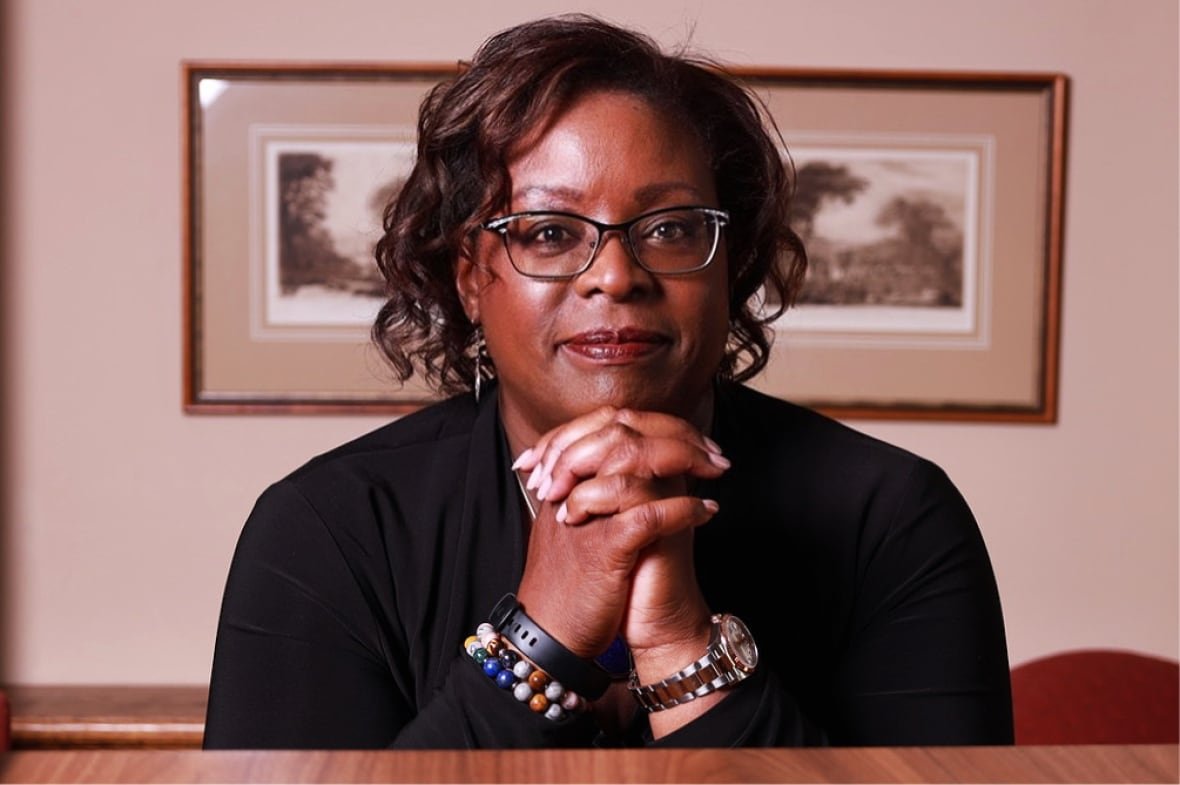 dr-helen-ofosu A Black woman poses for a photo in an office.