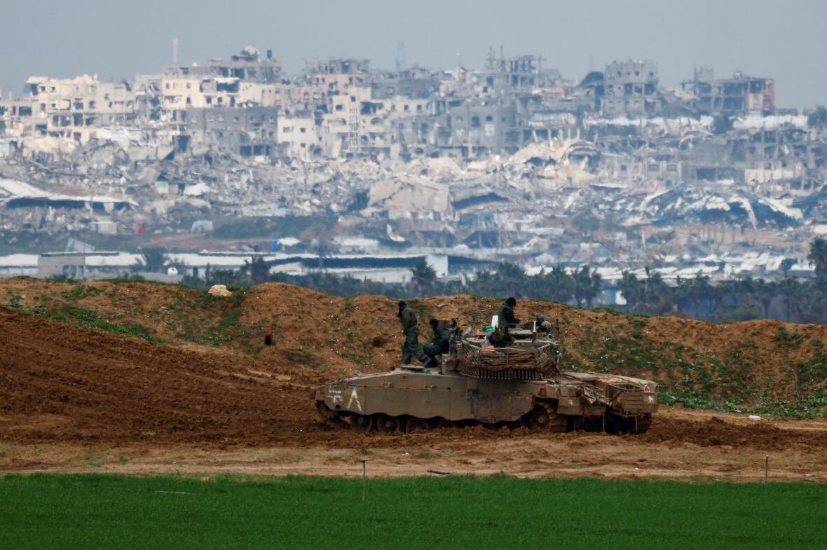 Soldiers gather on top of a tank.