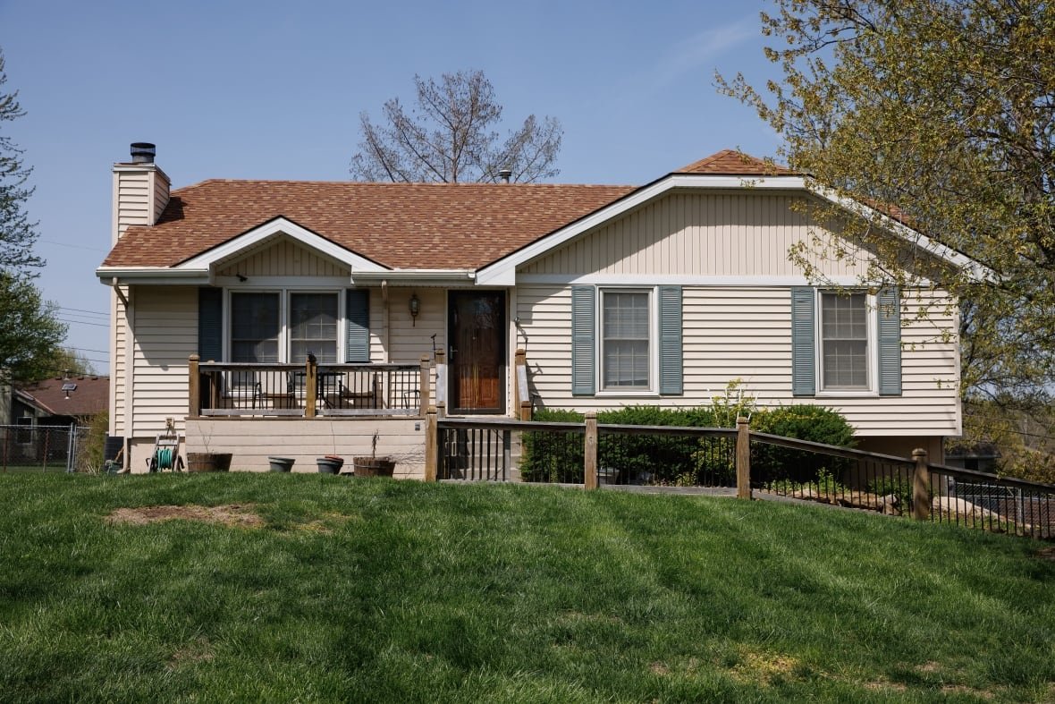 1251967057 A one-story home is shown with a green lawn from the street.