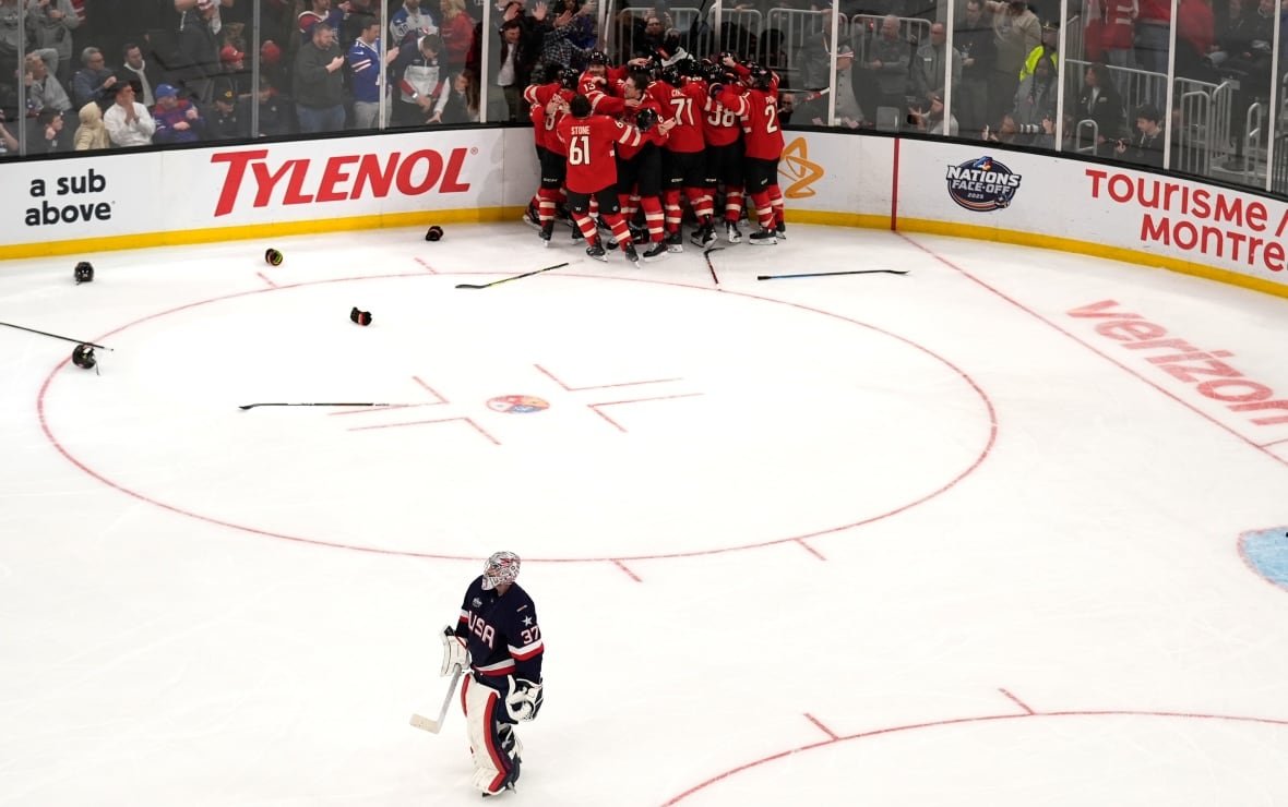 4-nations-canada-us-hockey-1 Canadian players celebrate as the Team USA goaltender skates off the ice.