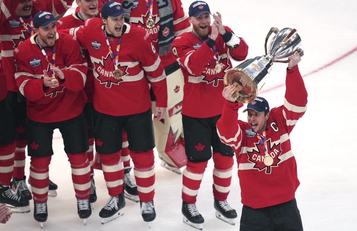 4-nations-canada-us-hockey A group of men's players celebrate as one raises a trophy.