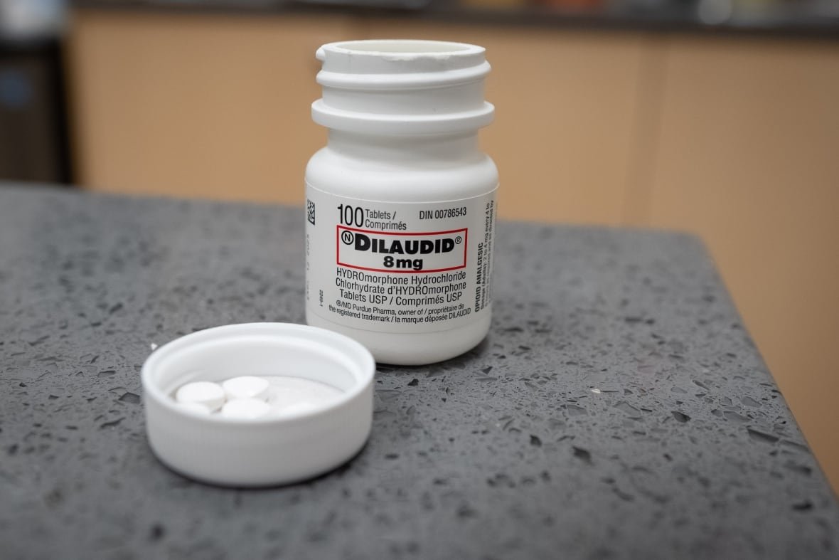 dtes-pharmacy-dilaudid-hydromorphone A bottle labeled dilaudid, a pharmaceutically made version of hydromorphone, is open with white pills in the lid, on a counter.