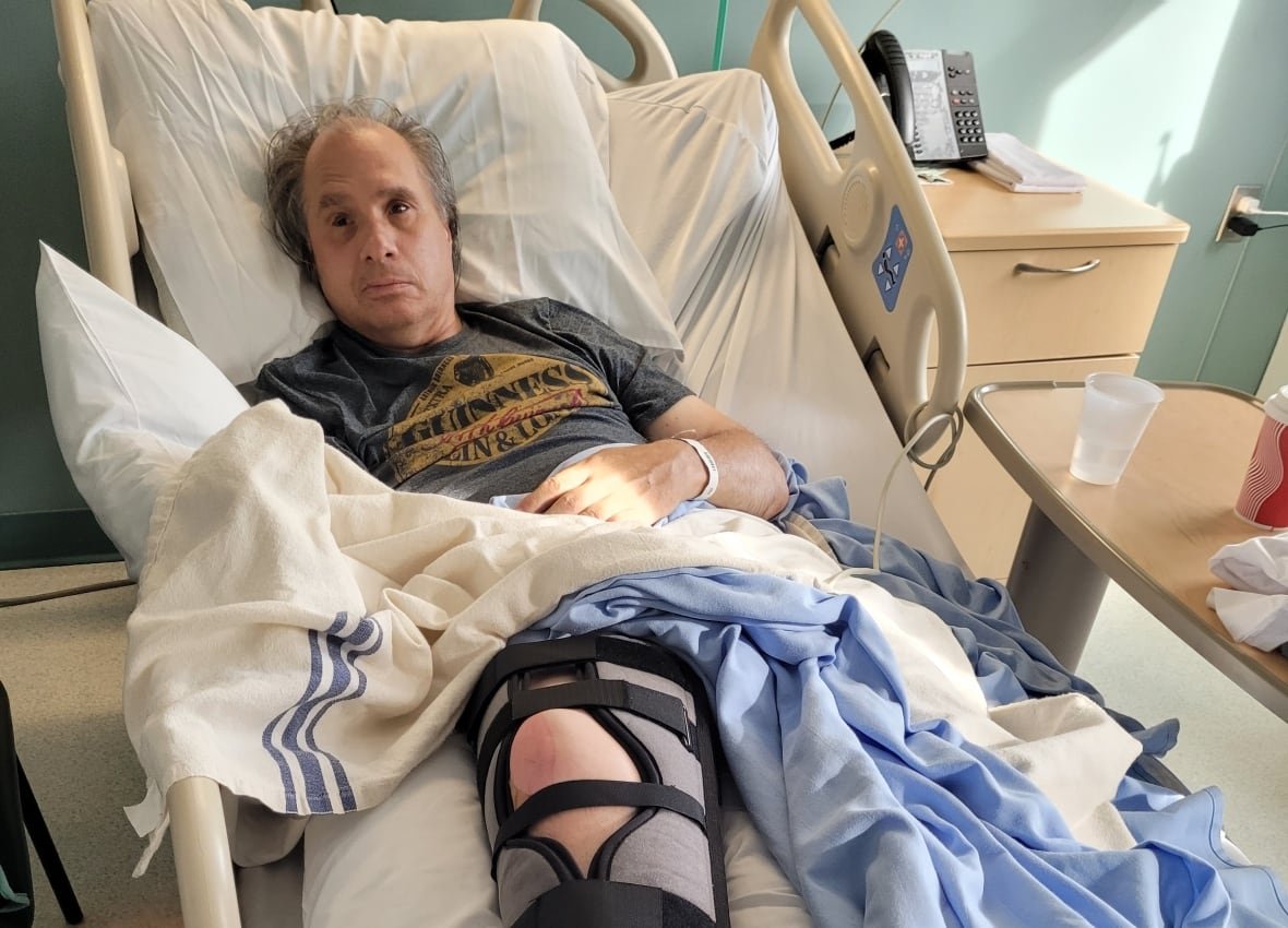 ken-rekowski-renfrew-victoria-hospital-may-2024 A man in a hospital bed wearing a knee brace.