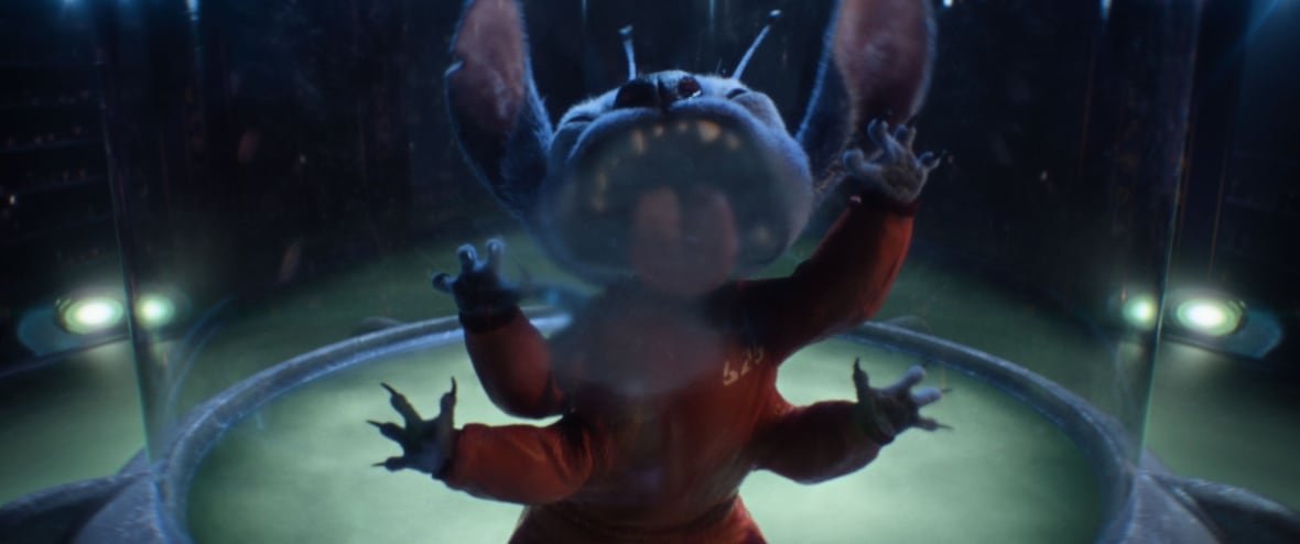 lilo-stitch A CGI blue alien licks at the inside of a glass container