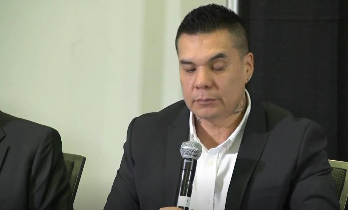 louis-kwissiwa-chief-of-netmizaaggamig-nishnaabeg A man speaks into a microphone