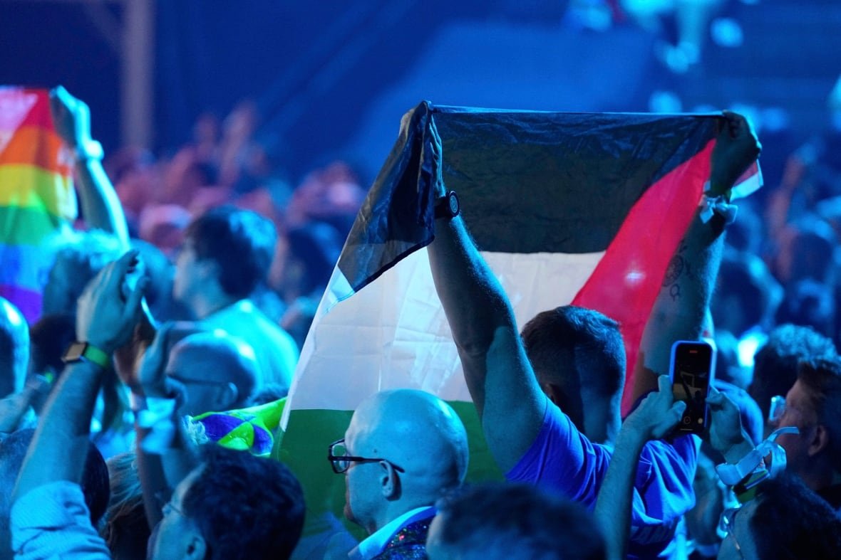 Audience members hold up flags.