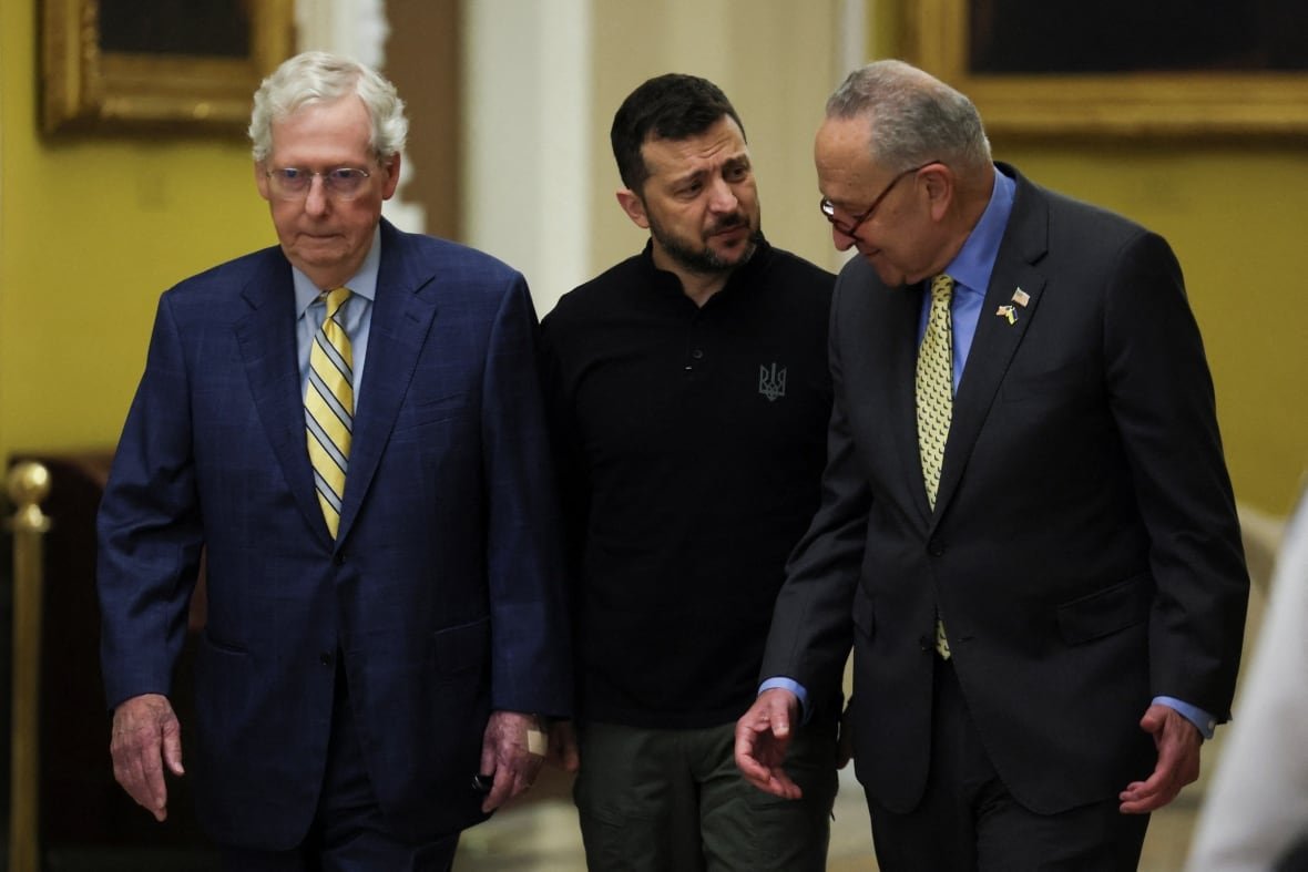 ukraine-crisis-usa-congress Three men walk together. A younger, dark haired and bearded man is flanked by two older clean shaven men in suits.