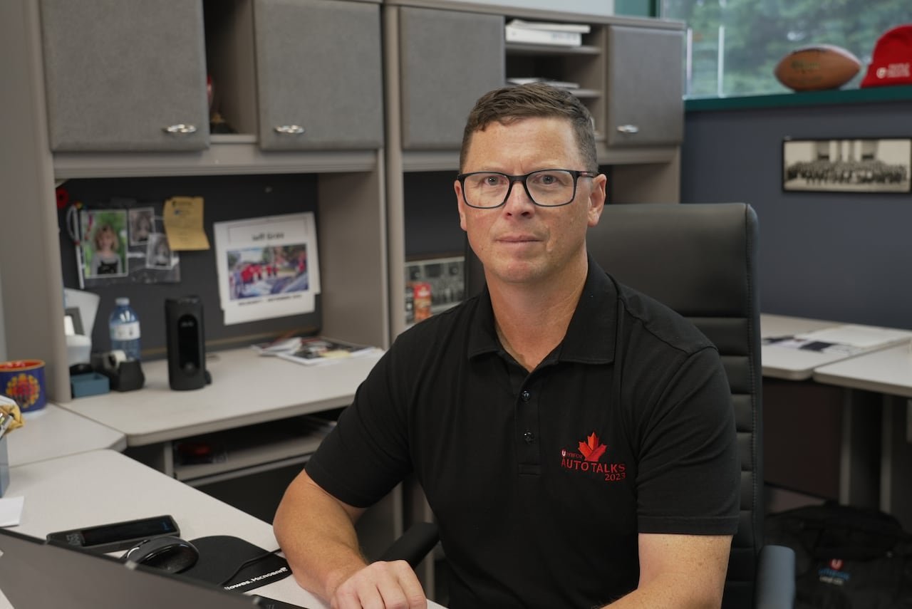 Photo of a man in a black t-shirt sitting at a desk