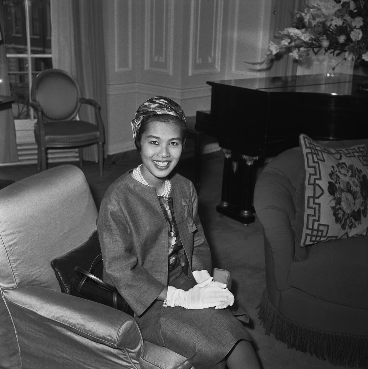 A person poses for a photograph in black and white.